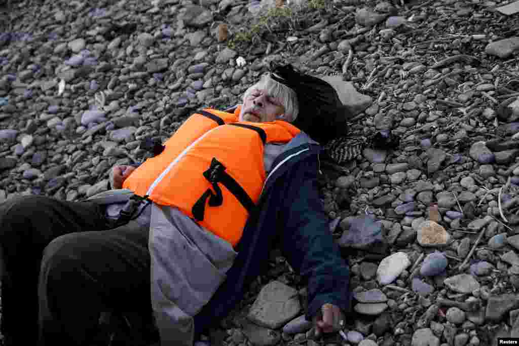 A migrant collapses from exhaustion, moments after arriving on a raft on the Greek island of Lesbos.