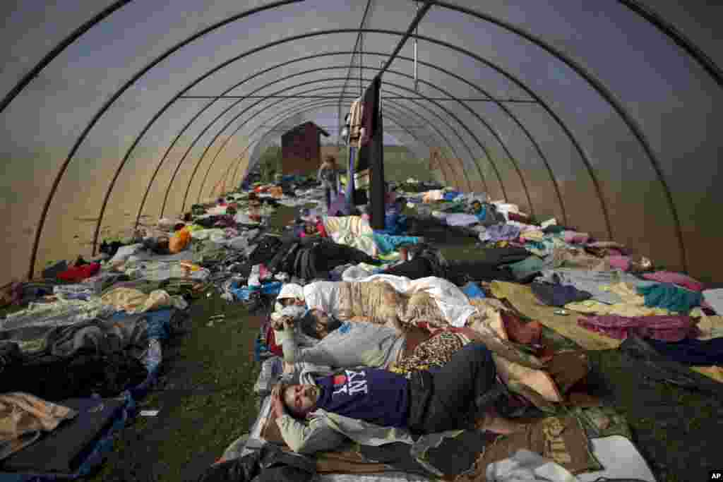 Hundreds of thousands of Syrian refugees and others are still making their way slowly across Europe, seeking shelter where they can, taking a bus or a train where one is available, walking where it isn&#39;t.&nbsp;People sleep inside a greenhouse at a makeshift camp for asylum seekers near Roszke, southern Hungary.