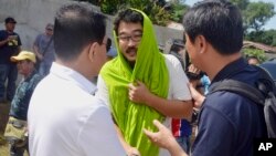 South Korean hostage Park Chul-hong (center) is greeted by unidentified officials as he prepares to board a plane for Davao city following his release Jan. 14, 2017, from his kidnappers in the volatile island of Jolo, southern Philippines. Park and Filipino companion Glen Alindajao were released Saturday after almost three months in captivity. 