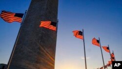 Tourists walk around the base of the Washington Monument on Presidents Day weekend as the sun sets. (File)