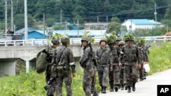 South Korean army soldiers patrol to search for a South Korean conscript soldier who is on the run after a shooting incident in Goseong, South Korea, Sunday, June 22, 2014.