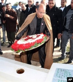 Tunisian President, Moncef Marzouki places flowers at the tombstone of Mohamed Bouazizi, a 26-year-old who set himself alight on Dec. 17, 2010