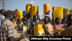 Chlorine is added to water that displaced women fetched from the Nile River during a water shortage at the UN base in Malakal where they are sheltering with thousands more. Aid groups fear a food shortage at the base unless fighting ends.