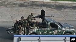 Unidentified troops drive past in the city of Abidjan, Ivory Coast, April 1, 2011