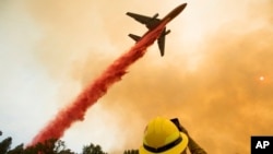 An air tanker drops retardant while battling a wildfire near Mariposa, Calif., July 19, 2017. The fire has forced thousands of people from homes in and around a half-dozen small communities, officials said.