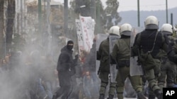 A protester holds a hammer during clashes with riot police in Athens, Friday, Feb. 10, 2012.
