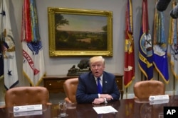 President Donald Trump, flanked by empty seats for Senate Minority Leader Sen. Chuck Schumer of N.Y., left, and House Minority Leader Nancy Pelosi of Calif., right, speaks in the Roosevelt Room of the White House in Washington during a meeting with congressional leaders, Nov. 28, 2017.