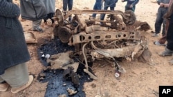 Civilians gather around the remains of a car bomb in the Rukban camp for displaced Syrians, inside Syrian territory, on the border with Jordan, Jan. 21, 2017. 