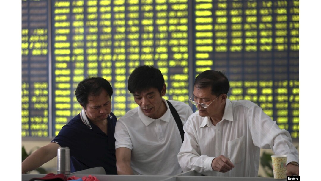 Sejumlah investor bercakap-cakap di di sebuah kantor pialang di Nantong, China (3/7).
