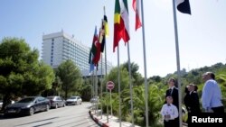 People look at flags ahead of the OPEC Ministerial Monitoring Committee in Algiers, Algeria, Sept. 22, 2018. 