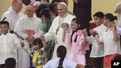 Paus Fransiskus menari dengan anak-anak Filipina pada kunjungan ke University of Santo Tomas di (18/1). (AP/Aaron Favila)