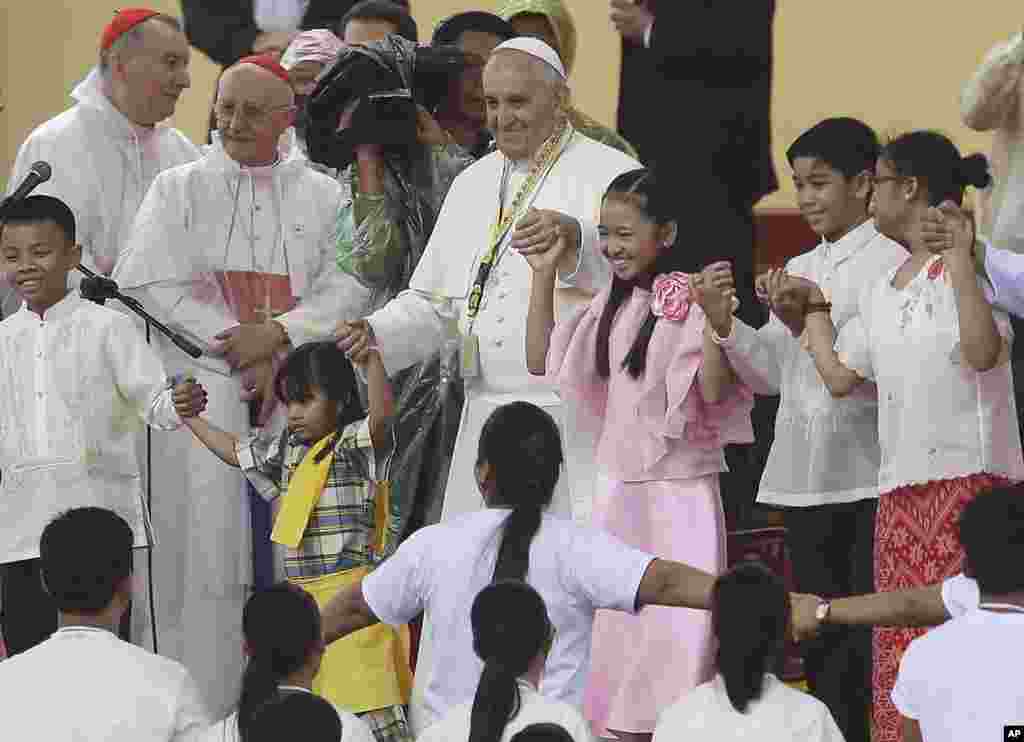 پاپ فرانسيس (وسط)، در جريان ديدارش از دانشگاه سانتو توماس در مانيل، با کودکان فيليپينی میرقصد&nbsp;-- ۲۸ دی ۱۳۹۳ (۱۸ ژانويه ۲۰۱۵)