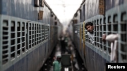 A passenger looks through the window of a stalled train as he waits for electricity to be restored at a railway station in New Delhi, India, July 31, 2012. 