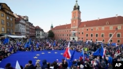 People wave EU and Polish flags in support of Poland's EU membership during a demonstration, in Warsaw, Poland, Sunday, October 10, 2021. 