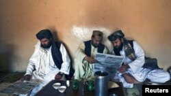 Pashtun men read local newspapers reporting the arrest of senior al Qaeda leader Younis al- Mauritani at roadside tea shop in Quetta.