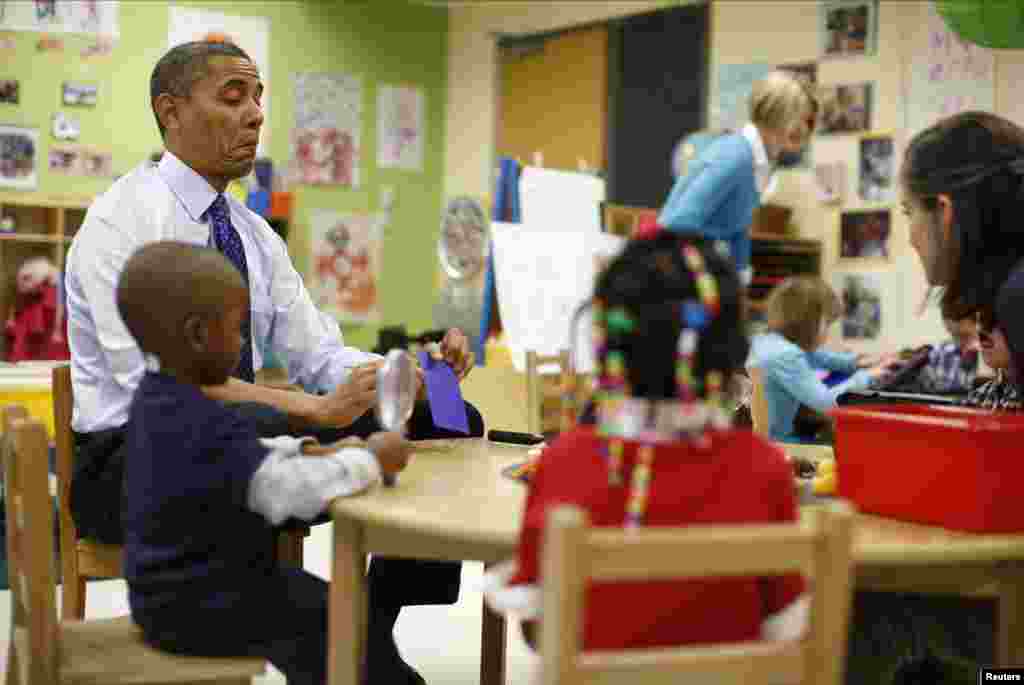 U.S. President Barack Obama reacts as he reads a card during a game with children in a per-kindergarten classroom at College Heights Early Childhood Learning Center in Decatur, Georgia. 
