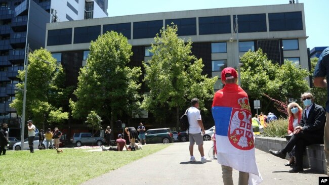 A fan of Serbia's Novak Djokovic stands outside the Park Hotel, used as an immigration detention hotel where the world's No. 1-ranked tennis player is detained in Melbourne, Australia, Jan. 9, 2022.