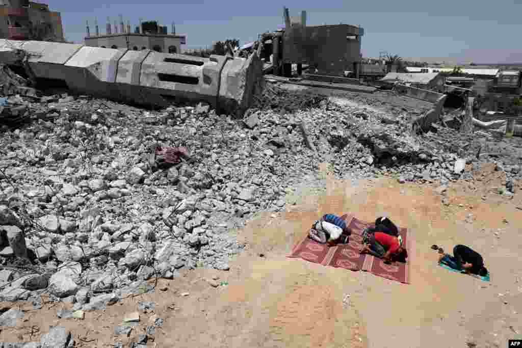 Palestinian Muslim worshippers pray near the rubble of a destroyed mosque in Beit Lahia, in the northern Gaza Strip.