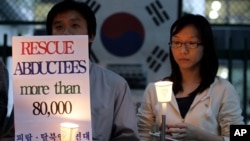 FILE - Members of the Korean Abductees to North Korea, the supporting group for those abducted by North Korea at the 1950-53 Korean War, participate at an anti-Koreas Summit candle rally in front of the government house in Seoul, South Korea, Oct. 2, 2007.