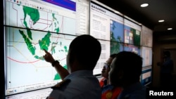 Military and rescue authorities monitor progress in the search for AirAsia Flight QZ8501 inside the National Search and Rescue Agency, Jakarta, Dec. 29, 2014.