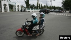 Perempuan Aceh naik sepeda motor di Banda Aceh, sesuatu yang hampir dilarang oleh pemerintah Lhokseumawe karena dianggap tidak pantas. (Reuters/Junaidi Hanafiah) 