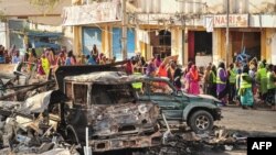 Des résidents regardent les dégâts fait par un attentat, à Mogadiscio, le 14 octobre 2017.