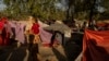 FILE - An internally displaced woman holds a child at a displaced persons camp in Kabul, Afghanistan, Sept. 13, 2021.