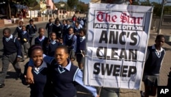Schoolchildren walk past a newspaper placard reporting the election victory of Jacob Zuma's African National Congress (ANC) party, based on preliminary results, in the Soweto township of Johannesburg, South Africa, May 9, 2014.