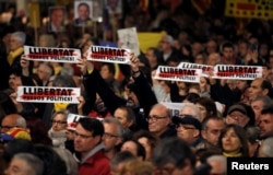 People protest against the Supreme Court at Catalunya Square in Barcelona, Spain, Feb. 12, 2019. Signs read, "Freedom for political prisoners."