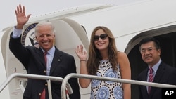 US Vice President Joe Biden, left, waves with his granddaughter Naomi Biden, center, and US Ambassador to China, Gary Locke, right, as they walk out from the Air Force Two upon arrival at the airport in Chengdu, China, August 20, 2011