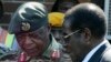 FILE - Zimbabwe's President Robert Mugabe, right, talks to General Constantine Chiwenga upon his arrival at Harare International Airport, July 4, 2008.