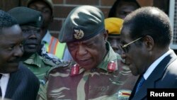 FILE - Zimbabwe's President Robert Mugabe, right, talks to General Constantine Chiwenga upon his arrival at Harare International Airport, July 4, 2008.