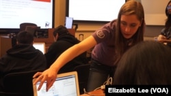 Allison Zubeck, a freshman studying industrial and systems engineering at USC helps school age students during a robotics workshop at the USC robotics open house.