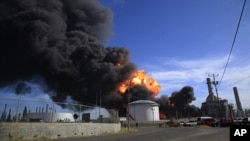 Plumes of black smoke and flames continue to rise over the Amuay refinery near Punto Fijo, Venezuela, Aug. 27, 2012. 