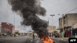 Des pneus brûlent alors que les manifestants barricadent les rues de Cadjehoun, fief de l'ancien président du Bénin, Thomas Yayi Boni, le 2 mai 2019 à Cotonou.