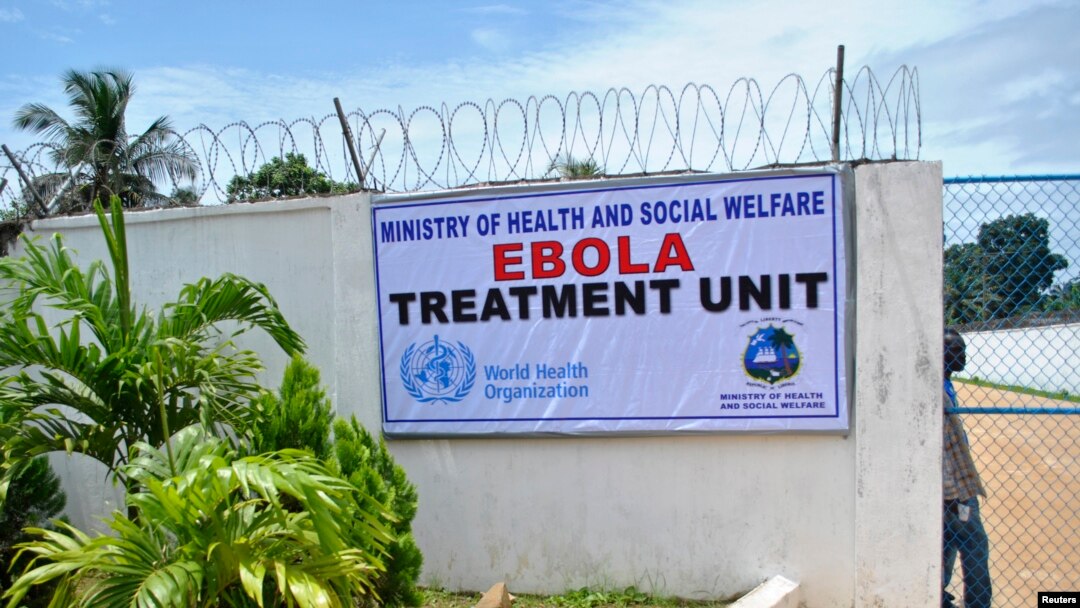 A man stands at the gate of an Ebola virus treatment center in Monrovia, Sept. 21, 2014. 
