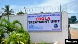 A man stands at the gate of an Ebola virus treatment center in Monrovia, Sept. 21, 2014. 