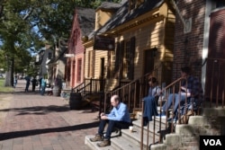 Turistas descansan el sábado 19 de octubre de 2024 en las escalinatas de una antigua casa colonial en la ciudad de Williamsburg, en Virginia, que entre 1691 y 1780 fue la capital de la Colonia de Virginia. [Foto: Tomás Guevara / VOA].