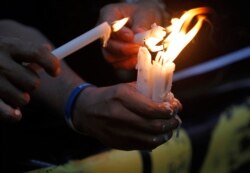 FILE - Filipino photojournalists light candles to commemorate the first anniversary of the killings in Maguindanao in southern Philippines during a protest rally in Manila, Nov. 23, 2010.