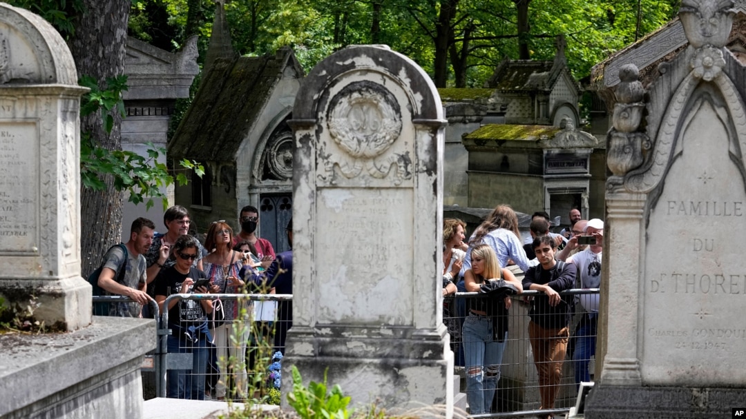 Fans gather at the tomb of rock singer Jim Morrison at the Pere-Lachaise cemetery in Paris, July 3, 2021. 