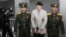 American student Otto Warmbier, center, is escorted at the Supreme Court in Pyongyang, North Korea, March 16, 2016. North Korea's highest court sentenced Warmbier to 15 years in prison after he allegedly attempted to steal a propaganda banner.