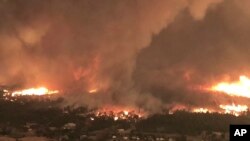 This July 26, 2018, image from video released by Cal Fire shows a fire tornado over Lake Keswick Estates near Redding, Calif. In the history of California wildfires there has never been anything like it: A churning tornado filled with fire, the size of th