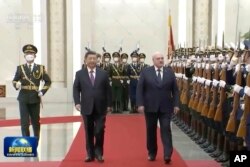 Presiden Belarusia Alexander Lukashenko, kanan, dan Presiden China Xi Jinping meninjau penjaga kehormatan dalam upacara penyambutan yang diadakan di Aula Besar Rakyat, di Beijing, 1 Maret 2023. (Foto: CCTV via AP)