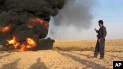 An Iraqi pipeline security guard inspects a damaged oil pipeline caused by a bomb explosion in the northern town of Kirkuk, 200 kilometers north of Baghdad, Iraq, Aug. 4, 2005.