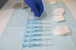 FILE - A nurse picks a syringe containing a dose of AstraZeneca's COVID-19 vaccine at a vaccination center in Barcelona, Apr. 26, 2021.
