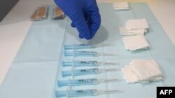 FILE - A nurse picks a syringe containing a dose of the AstraZeneca's COVID-19 vaccine at a vaccination center in Barcelona, Apr. 26, 2021. 