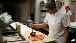 Andrea Ledesma es un graduado universitario, de 28 años, que trabaja haciendo pizzas en Milwaukee.