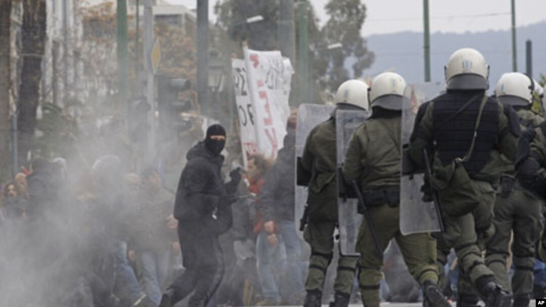 A protester holds a hammer during clashes with riot police in Athens, Friday, Feb. 10, 2012.