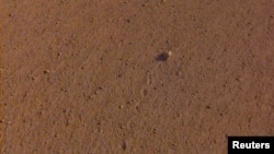 The "Rolling Stones Rock," slightly larger than a golf ball and named after the rock band, is seen on the surface of Mars after it rolled about 3 feet, spurred by the thrusters on NASA's InSight spacecraft, Nov. 26, 2018.
