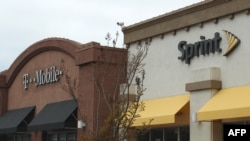 FILE - A T-Mobile and Sprint store sit side-by-side in a strip mall in El Cerrito, California, Apr. 30, 2018.